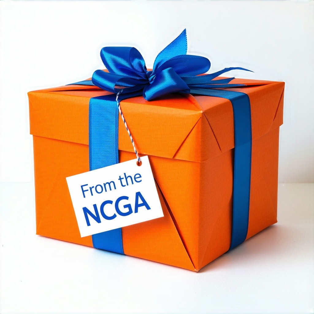 A side view of a big orange blue and white gift wrapped box with a white background blue bow and a small card saying From the NCGA